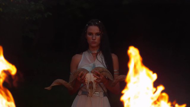 Dacian woman with ram skull and flames, slow motion