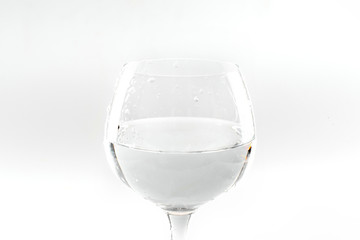 Wine glass partly filled with water isolated on white