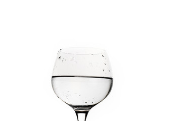 Wine glass partly filled with water isolated on white