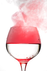 Wine glass with red smoke inside