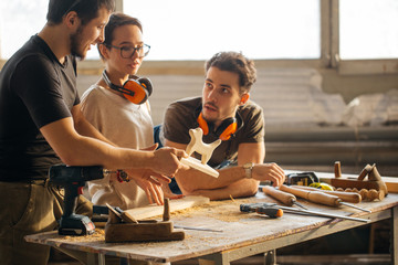 male Carpenter Training Female Apprentice To Use Plane