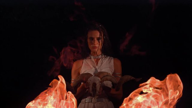 Dacian woman with ram skull and flames, slow motion