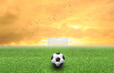 Soccer ball on grass sunset