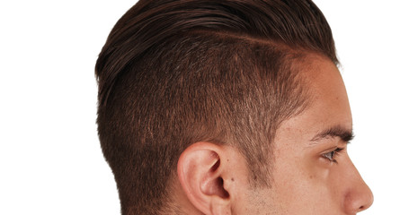 Close up Side view of Hispanic man with cool undercut standing with white background. Profile close up portrait of Latino millennial