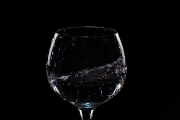 Water splashing out of a tall wine glass