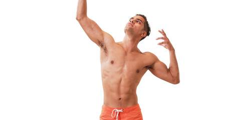 Happy Millennial Hispanic man posing in swim trunks on white background. Young guy doing silly poses having fun laughing.