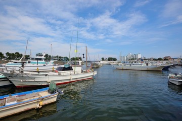Fototapeta na wymiar 片瀬漁港の停泊する漁船の影と白い雲