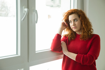 Red-haired girl by the window