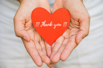 Young woman hand holding red heart paper with THANK YOU message. Thankful concept.