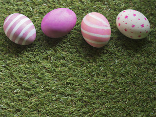 Top view of pink color theme Easter eggs with stripes, marble, line and stars pattern painting eggs on green grass for copy space, frame and background with Spring and Easter concept