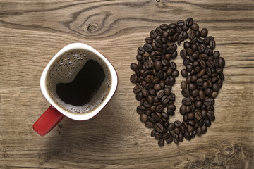 red mug on the background of scattered coffee beans