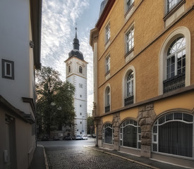 Fototapeta na wymiar Schmale Strasse und Kirchturm