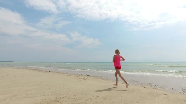 sportswoman runs along the beach