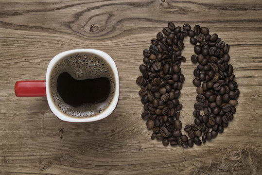 red mug on the background of scattered coffee beans