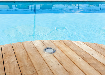 piscine avec plage en bois brut et spot d'éclairage intégré 