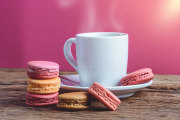 Different types color of macaroons with Cup of hot tea on Old grunge wooden background