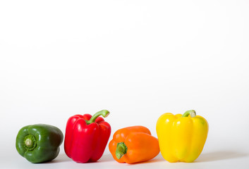 Four bell peppers in a row isolated on white background