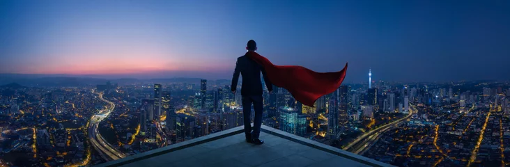 Foto op Canvas Businessman in suit and cape hero stand at rooftop looking great cityscape view and thinking business plan of the future . Night scene . © jamesteohart