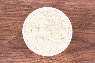 Heap of millet flour in glass bowl, healthy nutrition