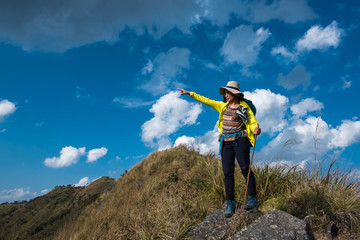 Hiker climbed on peak of rock, Hiking woman in mountains. Fitness and healthy lifestyle outdoors in summer nature