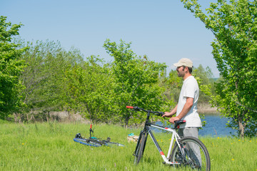 A young man with a Bicycle on nature background