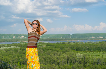 A red-haired young woman on nature background