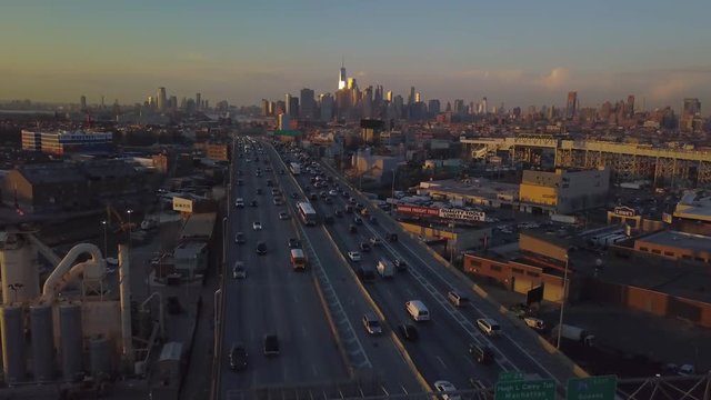 slower sunset flying backwards over highway away from Manhattan skyline
