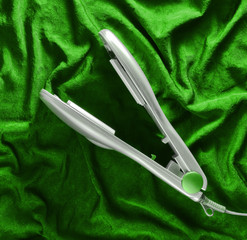 Hair thinning on a green silk background. Device for leveling hair. Top view.