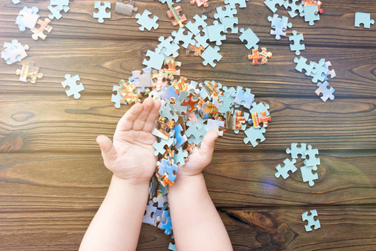 puzzles in hands on a wooden background