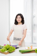 Healthy food. Asian woman cooking in the kitchen with wooden spoon