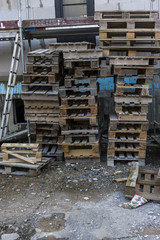 Baustelle Wohnhaus Gerüst zur Fassaden Dämmung mit mehreren Stapeln Holzpaletten, Construction site Residential building with scaffolding for facade insulation with several stacks of wooden pallets