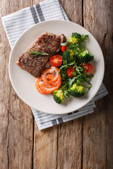 Delicious juicy barbequed steak and prawns with vegetable salad closeup. Surf and Turf style. Vertical top view