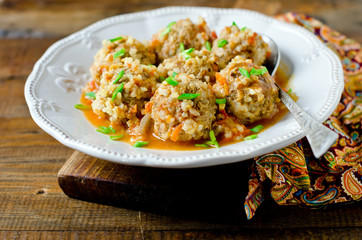 Meatballs stewed with tomato sauce in a plate on a wooden table