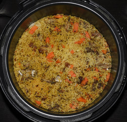 Pilaf cook in a saucepan of rice with lamb and vegetables