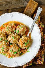Meatballs stewed with tomato sauce in a plate on a wooden table