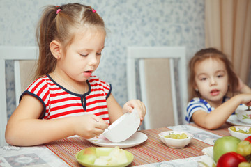 Sisters sitting by table and ready to eat dinner