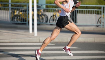 marathon runner legs running on city road