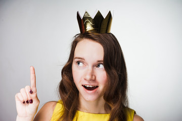 young beautiful girl in a yellow dress lifted her finger up, an idea appeared on her head, a golden...