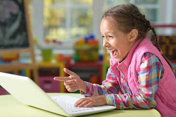 girl sitting at the table with laptop 