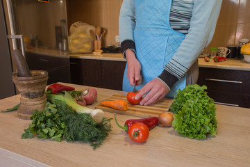 Man hands cutting vegetables on kitchen blackboard. Healthy food. Male preparing vegetables