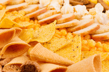 Decorative stripes pattern of crunchy spicy snacks, closeup. Fast food background.