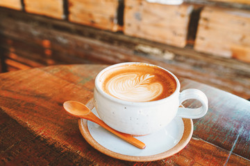Lattee art coffee cup on wood table