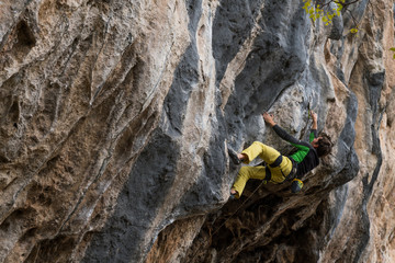 Men climbs a rock with a rope, lead