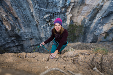 Girl climbs rock in a purple hat in a canyon, top view, Chitdibi, Turkey