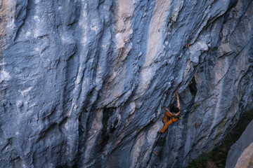Bare torso men climbs a tufa rock with a rope, lead, Turkey