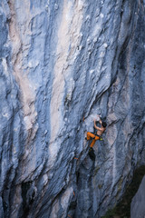 Bare torso men climbs a tufa rock with a rope, lead, Turkey