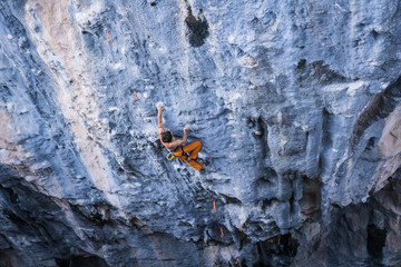 Bare torso men climbs a tufa rock with a rope, lead, Turkey