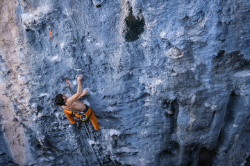 Bare torso men climbs a tufa rock with a rope, lead, Turkey