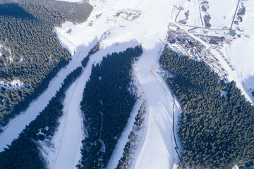 Fototapeta na wymiar Aerial view of the Alpine skiing and snowboarding resort in mountains