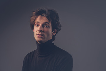 Close-up portrait of a charismatic sensual male in a black sweat